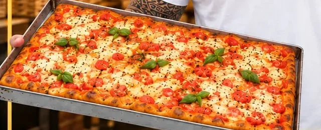 Teglia di focaccia al pomodoro con basilico appena sfornata da Panificio Falco